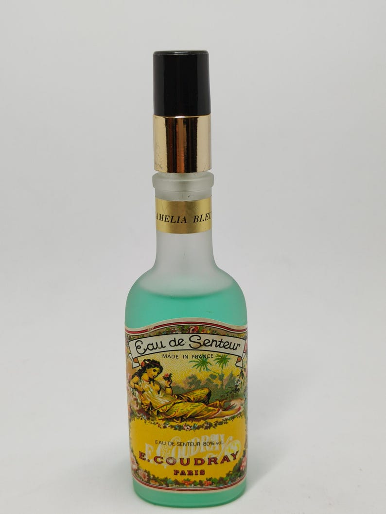 Puede incluir: Un frasco de perfume vintage con tapa negra y banda dorada. La botella esmerilada contiene un l&iacute;quido verde. La etiqueta dice "Eau de Senteur" y "E. Coudray Paris".