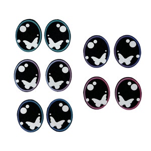 May include: Set of ten black and white butterfly eye stickers with a blue, purple, and pink gradient. The stickers are round and have a white butterfly design in the center.