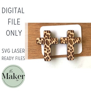 May include: Two wooden cross earrings with a leopard print design. The earrings are on a white card with a wooden background. The text "DIGITAL FILE ONLY" is above the earrings. The text "SVG LASER READY FILES" is below the earrings. The text "the Maker co." is in a circle below the earrings.
