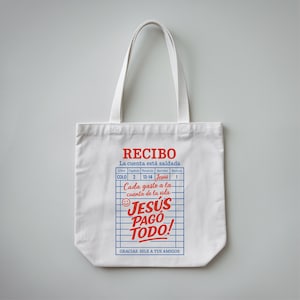 Może przedstawiać: Biała pł&oacute;cienna torba z czerwono-niebieskim nadrukiem, na kt&oacute;rym widnieje napis "RECIBO La cuenta est&aacute; saldada" oraz "JESUS PAGO TODO!" z uśmiechniętą buźką. Grafika przedstawia paragon z napisem "COLO 2 13-14 Jesus 1" oraz "Cada gasto a la cuenta de la vida". Tekst u dołu grafiki brzmi "GRACIAS. DILE A TUS AMIGOS".