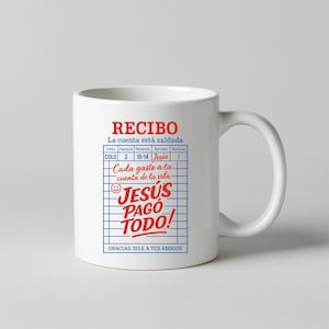 Może przedstawiać: Biały kubek ceramiczny z czerwono-niebieskim nadrukiem, na kt&oacute;rym widnieje napis "RECIBO La cuenta est&aacute; saldada" oraz "JES&Uacute;S PAGO TODO!" z uśmiechniętą buźką. Grafika przedstawia stylizowany paragon z napisami "COLO", "Cap&iacute;tulo", "Vers&iacute;culo", "Servidor" i "Factura" u g&oacute;ry.