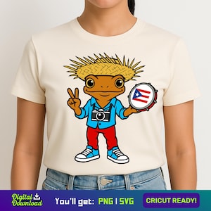 May include: Cream-colored t-shirt featuring a cartoon frog wearing a straw hat, blue shirt, red pants, and sneakers. The frog holds a drum with the Puerto Rican flag and makes a peace sign. The shirt also has the text "You'll get: PNG | SVG" and "CRICUT READY!"