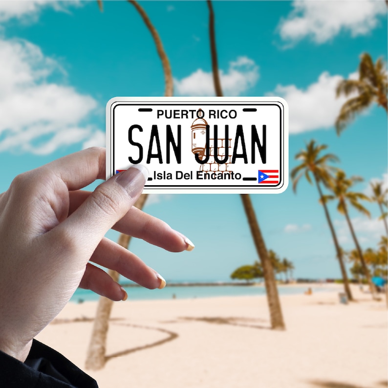 May include: White sticker with a black border and the text "PUERTO RICO" and "SAN JUAN" in black. The sticker also has a small image of a building and the text "Isla Del Encanto" in black.