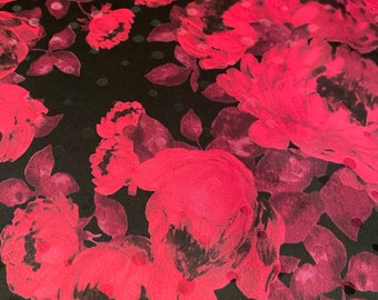 May include: Black fabric with a pink floral pattern. The flowers are large and have a watercolor effect. The background is a black polka dot pattern.