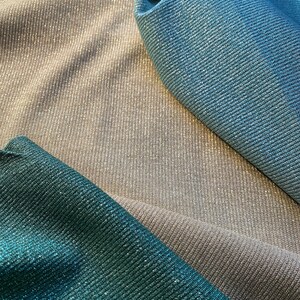 May include: Three fabric swatches in different colors: teal, silver, and light blue. The fabric has a shimmery, sparkly texture.