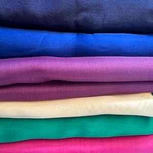 Peut inclure: Pile de six tissus transparents de couleurs différentes. Les couleurs sont bleu marine, bleu royal, violet, beige, vert sarcelle et rose vif.