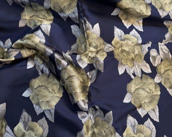 May include: Navy blue fabric with a gold and silver floral pattern. The fabric is textured and has a subtle sheen.