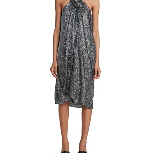 May include: A silver sequined halter dress with a knotted detail at the neckline. The dress has a loose, flowing fit and is midi length.