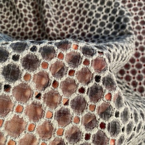 Peut inclure: Gros plan sur un tissu noir et blanc avec un motif circulaire. Le tissu est transparent et a un aspect d&eacute;licat et brod&eacute;.