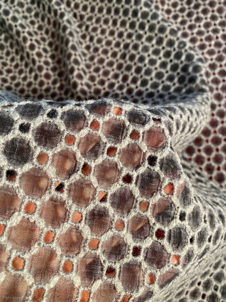 Peut inclure: Gros plan sur un tissu noir et blanc avec un motif circulaire. Le tissu est transparent et a un aspect d&eacute;licat et brod&eacute;.