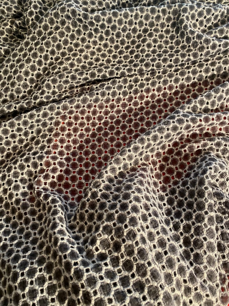 Peut inclure: Un tissu noir et blanc avec un motif g&eacute;om&eacute;trique de petits cercles et carr&eacute;s. Le tissu est textur&eacute; et a un aspect l&eacute;g&egrave;rement froiss&eacute;.
