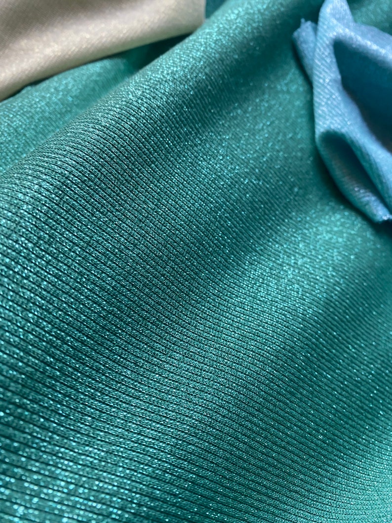 May include: Teal fabric with a subtle shimmer and a ribbed texture.