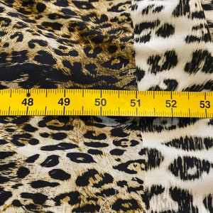 May include: Close-up of a yellow measuring tape with black markings, showing the numbers 48 to 53. The tape is placed on top of a fabric with a brown and black leopard print pattern.
