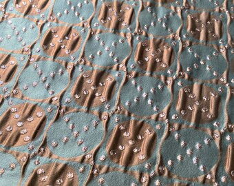 May include: A fabric with a repeating pattern of brown and teal circles. The circles are decorated with small silver sequins.