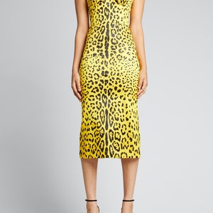 May include: A yellow midi dress with a black leopard print. The dress has short sleeves and a fitted bodice.