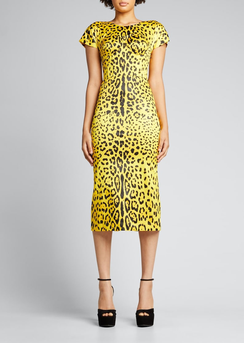 May include: A yellow midi dress with a black leopard print. The dress has short sleeves and a fitted bodice.
