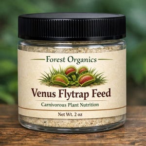 May include: A clear glass jar with a black lid, labeled "Forest Organics Venus Flytrap Feed." The label features an illustration of Venus flytraps and reads "Carnivorous Plant Nutrition." The jar contains a granular substance and is marked "Net Wt. 2 oz."
