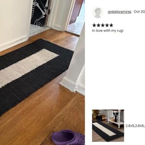 以下が含まれることがあります： 白と黒のストライプのランナーラグで、中央に白いストライプがあります。ラグは天然繊維で作られており、表面は質感があります。ラグは廊下の木製床に敷かれています。