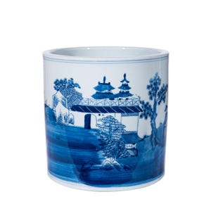 May include: A white ceramic cylinder planter with a blue and white design of a Chinese landscape. The design features a pagoda, trees, and a river.