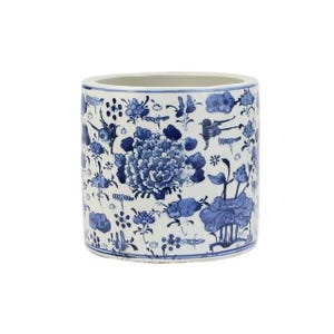 May include: A white ceramic cylinder planter with a blue and white floral pattern. The planter features a repeating design of flowers, leaves, and birds.