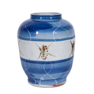 May include: A blue and white ceramic vase with brown insect designs. The vase has a rounded body and a narrow neck.