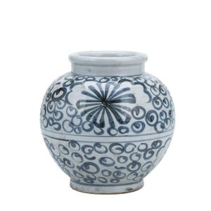 May include: A white ceramic vase with a blue and white floral design. The vase is round and has a wide mouth.