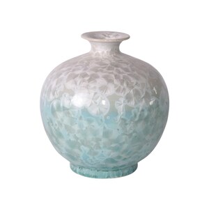 May include: A round, white and light blue ceramic vase with a mottled glaze.
