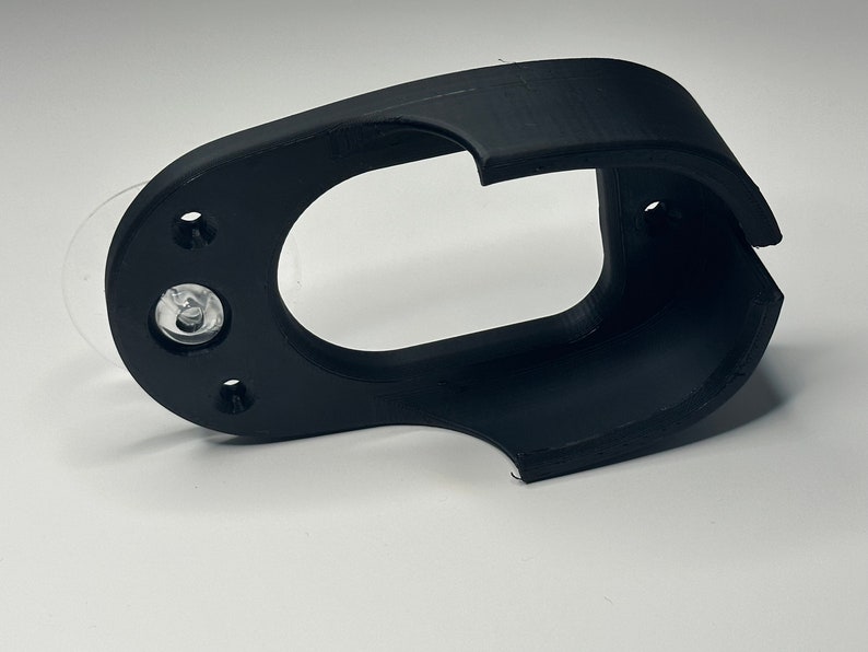 Puede incluir: Soporte de ventosa de pl&aacute;stico negro con una abertura circular. El soporte tiene una ventosa en la parte posterior y un peque&ntilde;o agujero en el lateral.