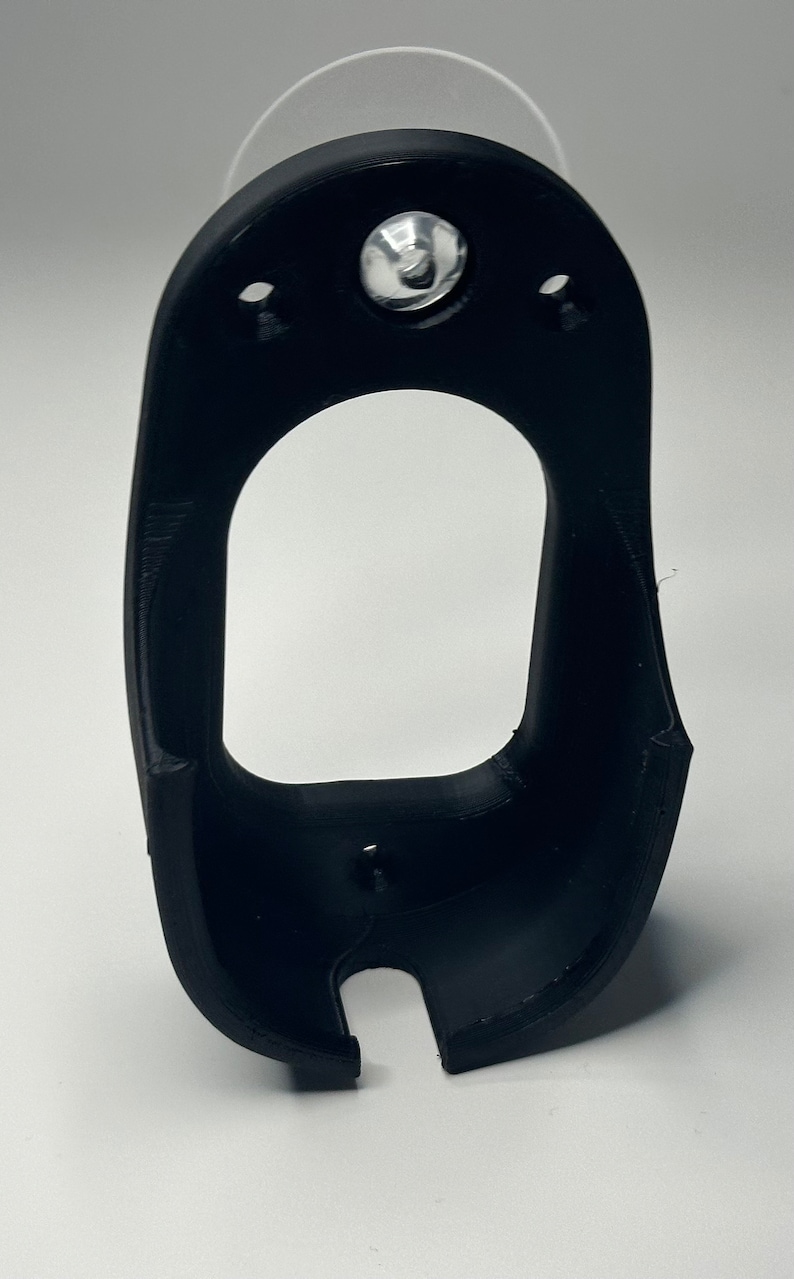 Puede incluir: Un soporte de tel&eacute;fono de pl&aacute;stico negro con una ventosa en la parte posterior. El soporte tiene un recorte para un tel&eacute;fono y un peque&ntilde;o agujero para un cable de carga.