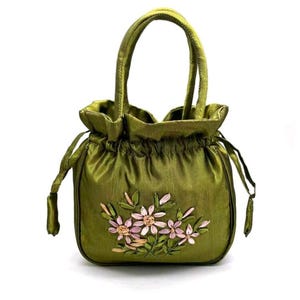 May include: Olive green satin handbag with a drawstring closure and two handles. The bag features an embroidered floral design in shades of pink and peach. The bag is approximately 8 inches tall.