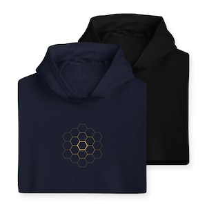 Puede incluir: Dos sudaderas con capucha, una azul marino y otra negra, con un diseño geométrico de panal de abeja dorado en la parte delantera de la sudadera azul marino.
