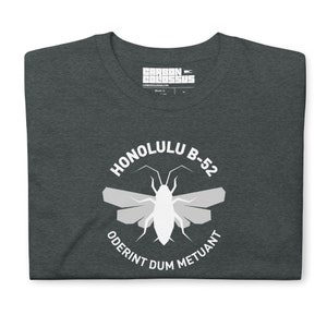 May include: A dark gray t-shirt with a white graphic design. The graphic features a stylized insect with wings and the text "Honolulu B-52 Oderint Dum Metuant".