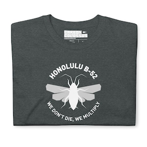 May include: A dark gray t-shirt with a white graphic of a cockroach with wings and the text "Honolulu B-52 We Don't Die, We Multiply".