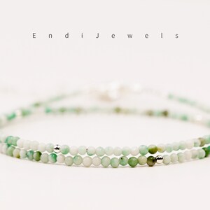 May include: A delicate double strand bracelet featuring small, light green beads with silver accents. The bracelet is made of natural stones and is perfect for everyday wear.