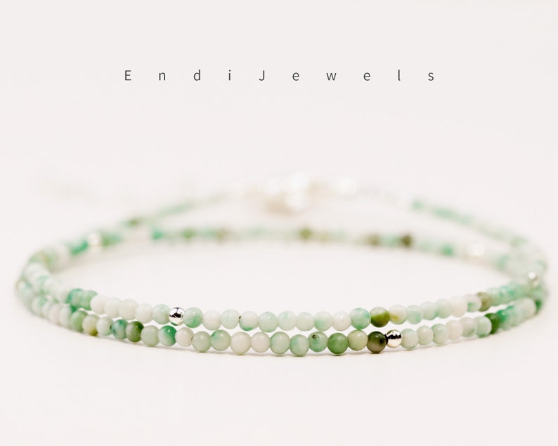 May include: A delicate double strand bracelet featuring small, light green beads with silver accents. The bracelet is made of natural stones and is perfect for everyday wear.
