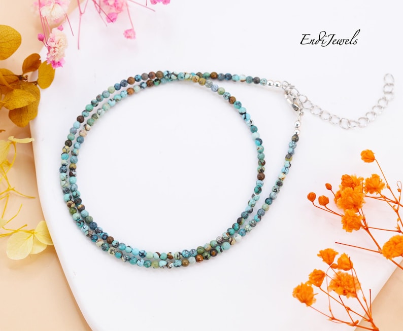Op de afbeelding: Een delicate ketting met twee rijen turquoise en bruine edelsteen kralen. De ketting heeft een zilveren sluiting en een verlengketting.