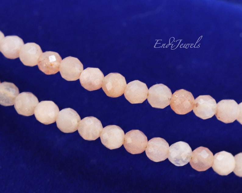 K&ouml;nnte beinhalten: Eine Str&auml;hne aus hellrosa Sunstone-Perlen mit facettierter Oberfl&auml;che. Die Perlen sind auf einem durchsichtigen Faden aufgef&auml;delt und in einer doppelten Reihe angeordnet.