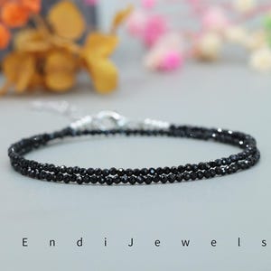 May include: A delicate double strand necklace made with black onyx beads. The necklace is made with a silver clasp.