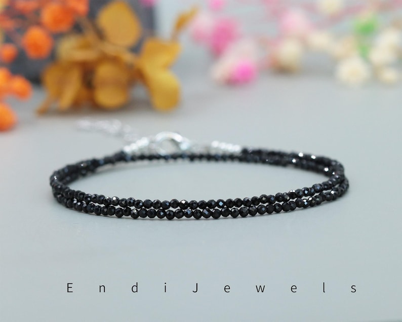 May include: A delicate double strand necklace made with black onyx beads. The necklace is made with a silver clasp.