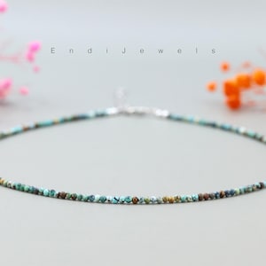 Op de afbeelding: Een delicate turquoise edelsteen ketting met een zilveren sluiting. De ketting is gemaakt van kleine, ronde kralen en is perfect voor dagelijks gebruik.