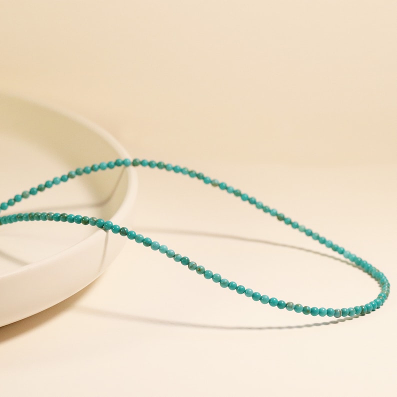 Puede incluir: Un collar de cuentas turquesa con peque&ntilde;as cuentas redondas. El collar es delicado y sencillo, y ser&iacute;a un gran accesorio para el d&iacute;a a d&iacute;a.