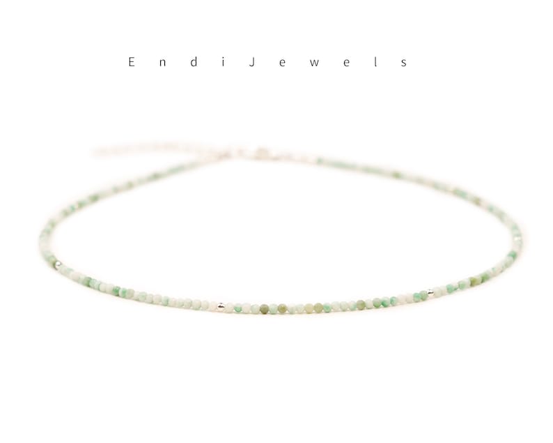 May include: A delicate green gemstone necklace with a silver clasp. The necklace is made of small, round beads and is perfect for layering.