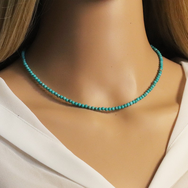 Puede incluir: Un collar de cuentas turquesa en un maniqu&iacute;. El collar est&aacute; hecho de peque&ntilde;as cuentas redondas y mide aproximadamente 40 cm de largo.