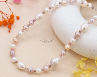 Könnte beinhalten: Eine zarte Perlenkette mit einem Mix aus weißen, rosa und lavendelfarbenen Perlen. Die Kette hat einen großen, unregelmäßig geformten Perlenanhänger.