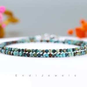 Op de afbeelding: Een armband met twee rijen van turquoise en bruine edelsteen kralen.