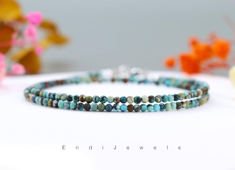 Op de afbeelding: Een armband met twee rijen van turquoise en bruine edelsteen kralen.