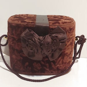 Cartera redonda grande color marrón vintage con detalle de lazo y correa larga para el hombro