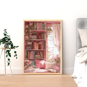 May include: A framed print depicts a cozy reading nook. A pink bookshelf is filled with books, and a window with pink curtains is visible. Pink pillows and open books rest on a window seat, with floral accents.