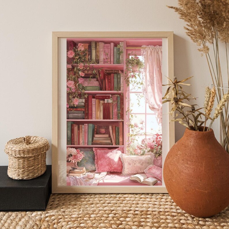 May include: A framed print depicting a cozy reading nook with a pink bookshelf filled with books. The scene includes pink pillows, a window with pink curtains, and floral accents. A woven basket and a terracotta vase are in the foreground.
