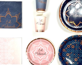 May include: A set of party supplies featuring a blue and gold geometric pattern with the text "Eid Mubarak". The set includes paper plates, napkins, cups, and a tablecloth.